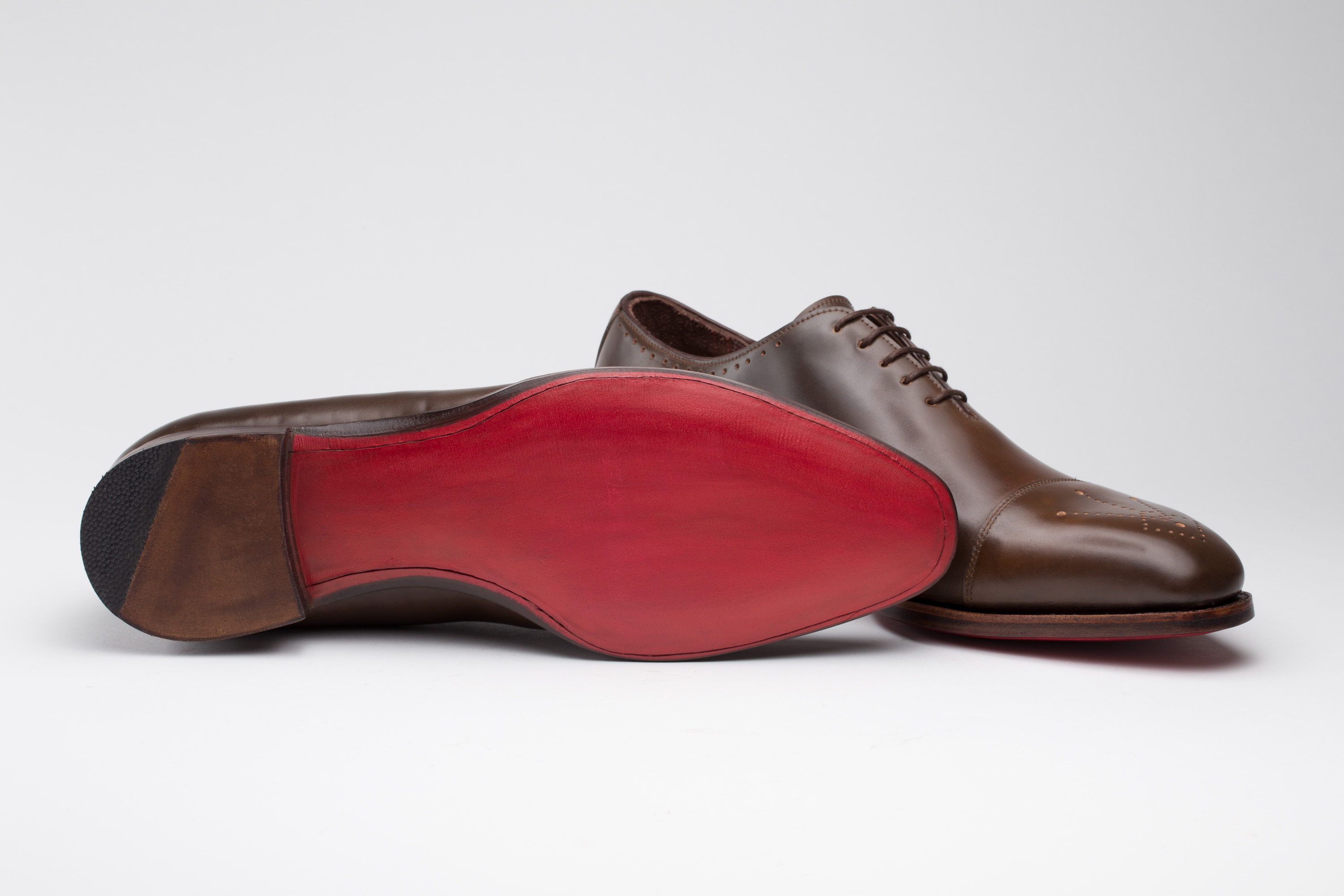Herren Maßschuhe aus braunem Pferdeleder mit einer rot ausgearbeiteten Ledersohle